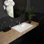 Zu sehen ist ein rechteckiges Waschbecken von Kaldewei in Weiß, eingelassen in einen Holzwaschtisch, in einem schwarz minimalistischen Badezimmer.