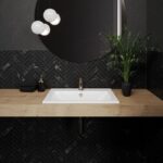 Zu sehen ist ein rechteckiges Waschbecken von Kaldewei in Weiß, eingelassen in einen Holzwaschtisch, in einem schwarz minimalistischen Badezimmer.