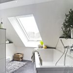 Die großzügige Dachfensterlösung lässt dank viel Tageslicht und einem freien Blick nach draußen das Bad optisch größer wirken.