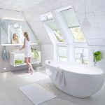 Ganz in hellem, skandinavischem Stil gehalten ist dieses Dachgeschoss-Bad. Grüne Farbakzente setzen Handtücher und Accessoires sowie mintgrüne Plissees, die als Sicht- und Sonnenschutz vor den Dachfenstern dienen.