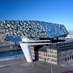 Das neue Headquarter der Hafenbehörde von Antwerpen entsteht aus dem Zusammenspiel dreier räumlicher Elemente: dem denkmalgeschützten Bestandsgebäude, einer Betonbrücke und dem vertikalen Erweiterungsbau.