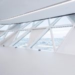 Der Wechsel von transparenten und opaken Fassadenelementen führt zu einer Brechung des Gebäudevolumens, dessen transparent erscheinende Oberfläche sich mit der wechselnden Intensität des Tageslichts verändert.