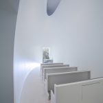 Beleuchtet wird die Kapelle indirekt über den Zwischenraum zwischen Wänden und dem überspannenden Deckensegel, das als Reflektor dient.