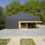 Für einen Besucherpavillon im niederländischen Putten wählten die Architekten anthrazitfarbene Faserzementplatten, um einen Kontrast zur natürlich grünen Umgebung zu erzeugen.